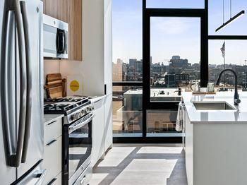 a kitchen with a view of a city and a refrigerator and a sink